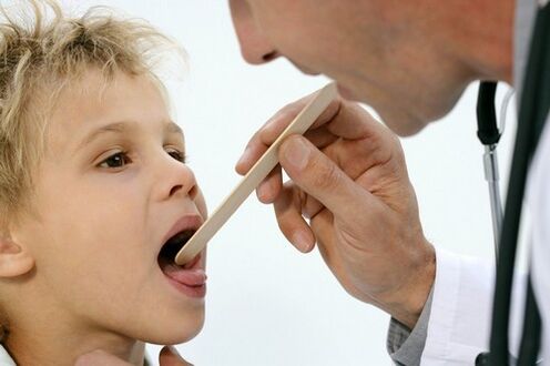 the doctor examines the throat of a child with psoriasis
